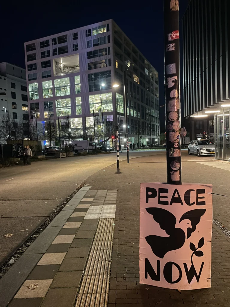 Sign reading PEACE NOW with a bird silhouette